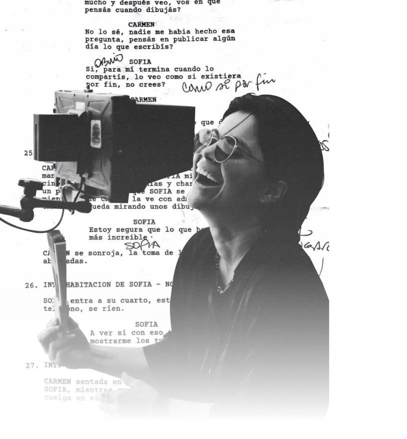 A director laughs behind a field monitor, over a page of handwritten script notes